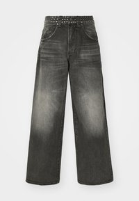 Svarta denimbyxor med breda ben och en urtvättad yta samt nitar i midjan. Har två framfickor och en avslappnad passform.