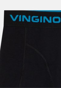 Fekete férfi alsónemű vastag derékpánttal, amelyen kék "VINGINO" logó található, a kényelemre helyezve a hangsúlyt, varrás nélküli kialakítással és puha textúrával.