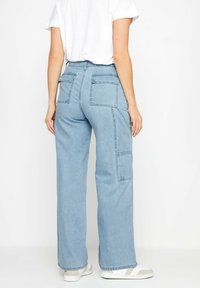 Jeans de tiro alto y corte relajado en denim de color azul claro, con perneras anchas, dos bolsillos traseros y bolsillos tipo cargo en los laterales.