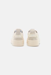 Sneakers platform beige viste da dietro con linguette in camoscio sul tallone e le scritte "LIU JO" e "LOVE" stampate sulle cinghie sopra suole spesse.