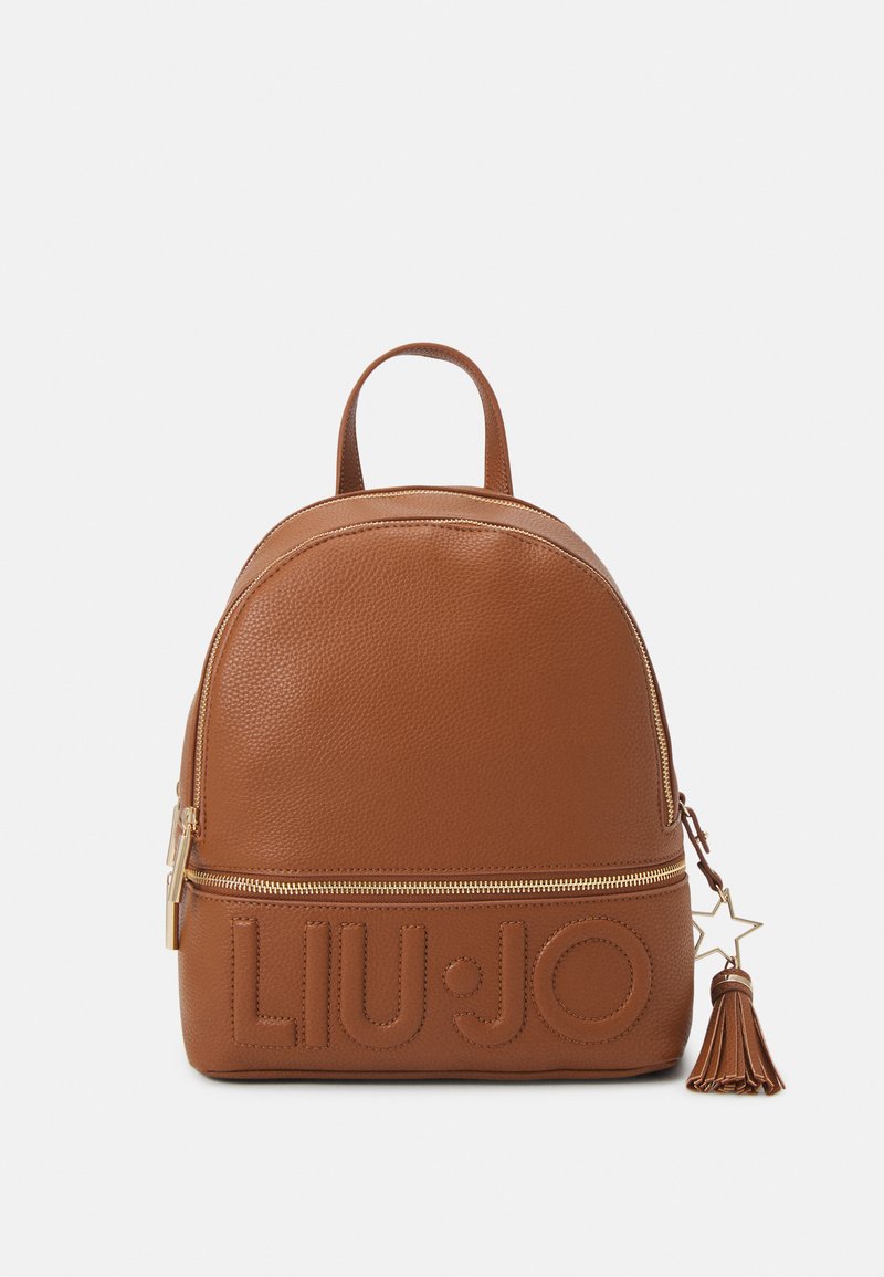 Brauner Leder-Rucksack mit strukturierter Oberfläche, abgerundetem oberen Teil, goldenen Beschlägen, geprägtem Markenlogo und einem Quastenakzent am Reißverschluss.
