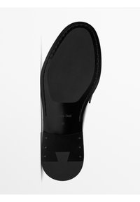 Black shoe sole with smooth texture, rounded shape, and small circular hardware accents. Features branded logo and size label (42).