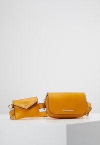 Borsa a tracolla in pelle gialla con finitura testurizzata, dotata di patta frontale e piccola pochette staccabile con chiusura a scatto.