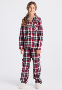 Conjunto de pijama a cuadros rojos y verdes, hecho de algodón, que incluye una camiseta con botones, mangas largas, un bolsillo en el pecho y pantalones a juego. Textura suave.