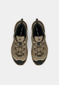 Ταν παπούτσια πεζοπορίας με επάνω μέρος από δίχτυ, μαύρο καπάκι δακτύλου από καουτσούκ και ελαστικά κορδόνια. Διαθέτουν θηλιά στο τακούνι για εύκολη φορεσιά.