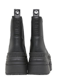 Bottines en cuir noir avec une semelle plateforme épaisse, arborant le logo "BUFFALO" en relief et des accents métalliques à l'arrière.
