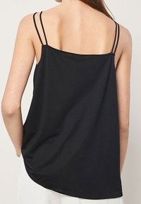 Musta toppi, jossa on ohuet kaksinkertaiset spagettiolkaimet, löysä istuvuus ja sileä, pehmeä pinta. Takana pyöristetty helma.