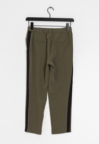 Olive green pants with black side stripes, elastic waistband, two back pockets, and a smooth, lightweight fabric texture.