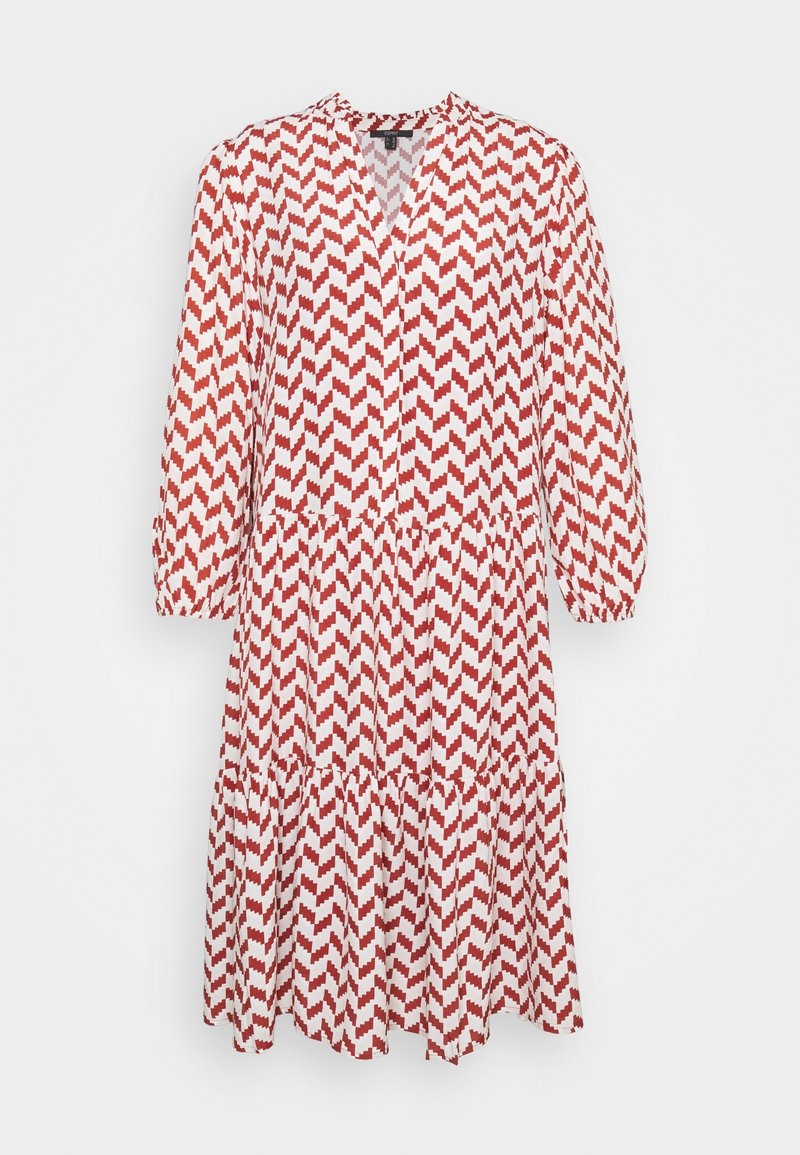 Robe midi à manches longues avec motif zigzag rouge et blanc, encolure en V, poignets élastiques et jupe à volants, suspendue sur un fond blanc.