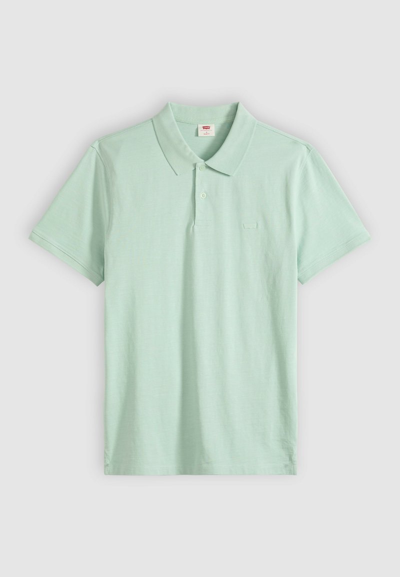 Lichtgroen poloshirt met korte mouwen, kraag en twee knopen, plat neergelegd op een lichtgrijze achtergrond.
