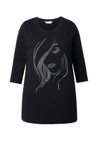 Schwarzes Langarmshirt mit einem Strassdesign eines Frauenortes mit geschlossenen Augen und einer Hand, die auf ihrer Wange ruht.
