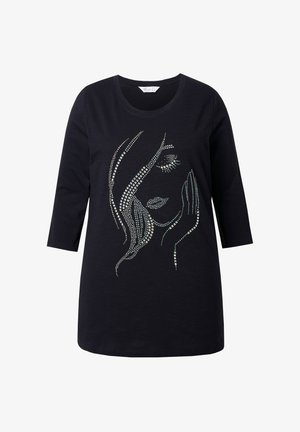 Schwarzes Langarmshirt mit einem Strassdesign eines Frauenortes mit geschlossenen Augen und einer Hand, die auf ihrer Wange ruht.
