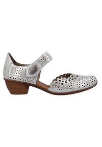 Zapato tipo Mary Jane plateado con patrones de flores recortados, punta redonda, un tacón bajo similar a la madera y una correa con detalle de botón decorativo.