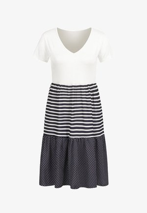 Balta V formos iškirptės palaidinė su tamsiai mėlynomis juostelėmis liemens srityje ir sijonas su taškuotu raštu. Trumpomis rankovėmis, suglebusi juosmens dalis ir laisvai krentantis, sluoksniuotas dizainas.