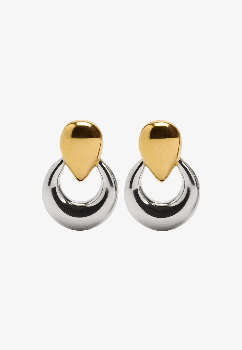 Kolczyki z metalu złotego i srebrnego mają kształt łezki u góry, połączone z okrągłym kółkiem, z połyskującą, refleksyjną powierzchnią.