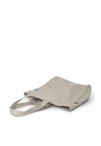Borsa a tracolla in tela beige con doppi manici in tessuto, caratterizzata da una texture morbida e un design minimale, leggermente collapsing con cuciture visibili.