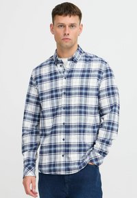 Camicia a maniche lunghe in flanella da uomo con motivo a quadri, caratterizzata da colori blu navy, bianco e azzurro chiaro, chiusure a bottone e una vestibilità comoda.