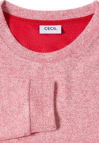 Suéter melange rojo y rosa con cuello y puños de canalé. La etiqueta dice "CECIL". Textura suave con una tela ligeramente elástica.