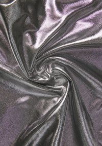 Tessuto metallico in tonalità di nero e argento, con una consistenza liscia e lucida. Il materiale è stropicciato e piegato, evidenziando le qualità riflettenti.