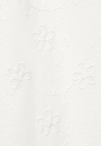 Bijeli materijal s reljefnim cvjetnim uzorkom, koji sadrži male cvjetove i liste. Tekstura je glatka i mekana, s blagim sjajem.