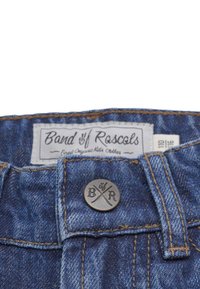 Denim lasten farkut sinisessä sävyssä, näkyvillä ompeleilla, napilla, jossa on "B/R" kaiverrus sekä merkkilappu vyötäröllä.