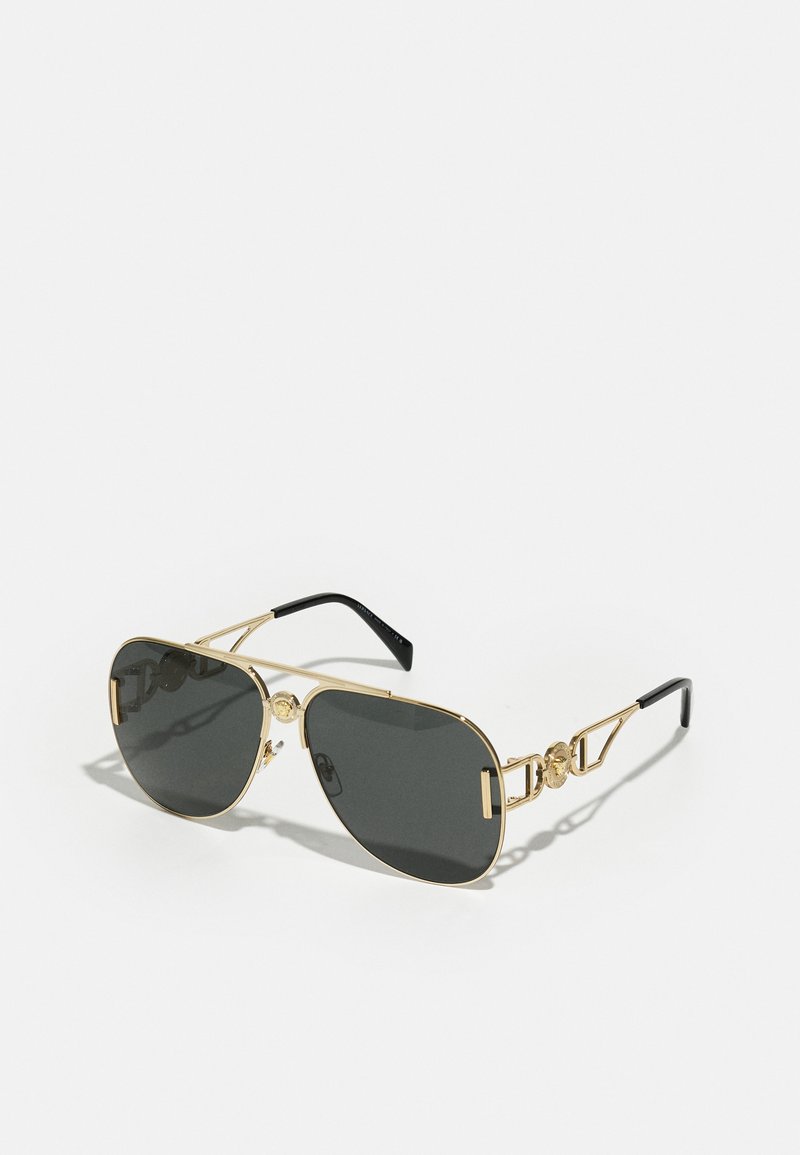 Ochelari de soare din metal aurit cu lentile gri închis, formă pătrată și accente decorative pe brate. Vârfuri negre pentru un plus de confort.