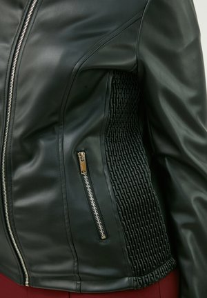 Schwarze Lederjacke mit strukturierten, gewebten Seiteneinsätzen, silbernen Reißverschlüssen und tailliertem Schnitt. Verfügt über eine glatte Oberfläche und strukturierte Nähte.