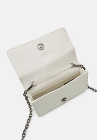 Jasnozielona kopertówka o gładkiej fakturze, z zapięciem na zatrzask magnetyczny i łańcuszkiem. Wnętrze wyposażone w przegródki na karty oraz płaską kieszeń.