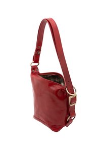Sac bandoulière en cuir rouge avec une finition brillante, une sangle réglable et un doublure à carreaux. Il dispose d'une fermeture zippée et d'accents en métal.