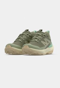 Πράσινα αθλητικά παπού τσια με υφασμάτινο επάνω μέρος με υφή, ενισχυμένη μύτη, ανοιχτοπράσινες λεπτομέρειες και μπεζ λαστιχένια σόλα με σχεδιασμένο πέλμα.