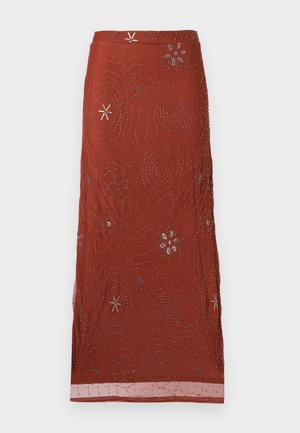 Jupe longue rouge rouille avec une broderie complexe de perles argentées présentant des motifs floraux et abstraits partout.