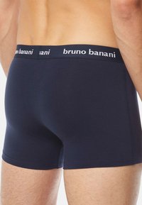 Mörkblå boxertrosor i mjukt tyg, med en elastisk midja med logotyp och snygg sömnad, designade för komfort och passform.