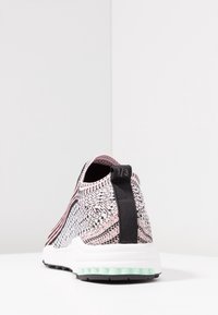 Sneakers med slip-on-design och en texturerad stickad ovandel i svart, vitt och rosa, med en svart hälflik och vit mellansula med mintgrön yttersula.