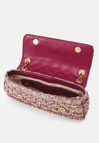 Borsa intrecciata rosa e bianca con texture, dotata di un interno in pelle lucida rosa scuro. Presenta accessori in oro e una tasca interna con zip.
