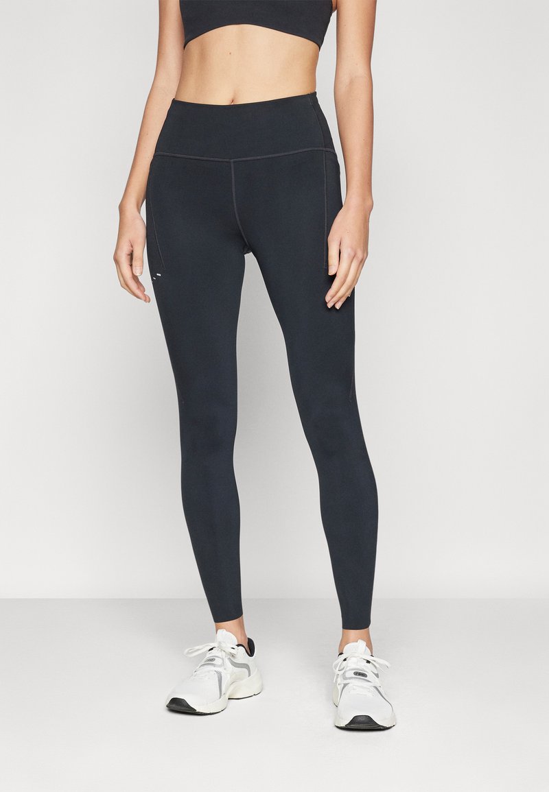 Zwarte high-waisted legging van rekbaar materiaal, met een gladde textuur en platgestikte naden voor comfort en duurzaamheid.
