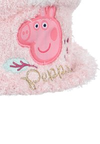 Roze, fluffy muts met een geborduurde Peppa Pig gezichtsafbeelding, voorzien van naamdetail in gouden draad en een decoratief blad in groene en roodachtige kleuren.