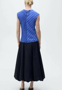 Blue sleeveless top with diagonal white stripes; black, full-length skirt with a rounded hem. Model shown from the back.