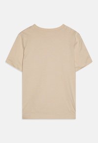 Světle béžové tričko s krátkým rukávem, měkká bavlněná textura, kulatý výstřih, rovný lem, minimalistický design bez viditelných vzorů nebo akcentů.