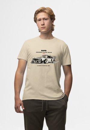 Beige bomulds T-shirt med et grafisk motiv af en racerbils, med sort tekst som siger "RAPID AIRFIELD TRACK STAR" ovenover. Løs pasform.