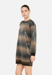 Vestito a maglia con motivo sfumato in tonalità di marrone, nero e dettagli metallici, con scollatura a girocollo e maniche lunghe.