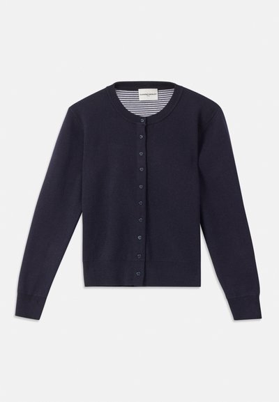 Marineblå cardigan med rund hals, lange ermer, frontlukking med knapper og ribbestrikket kant. Innvendig har den et stripete mønster.