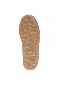 Semelle d'une chaussure, présentant une surface en caoutchouc texturé de couleur brun clair avec un design à motifs et un petit logo.