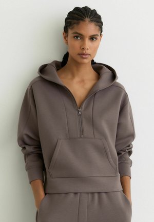 Kapuzensweatshirt mit Reißverschluss aus strukturiertem taupefarbenem Stoff mit einer Fronttasche und gerippten Bündchen, das eine lockere Passform und nahtlose Designakzente bietet.