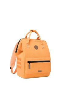 Oranger Rucksack mit strukturiertem Design, verstellbaren Trägern, frontalem Reißverschlusstaschen, Logo-Patch und strukturiertem Stoff.