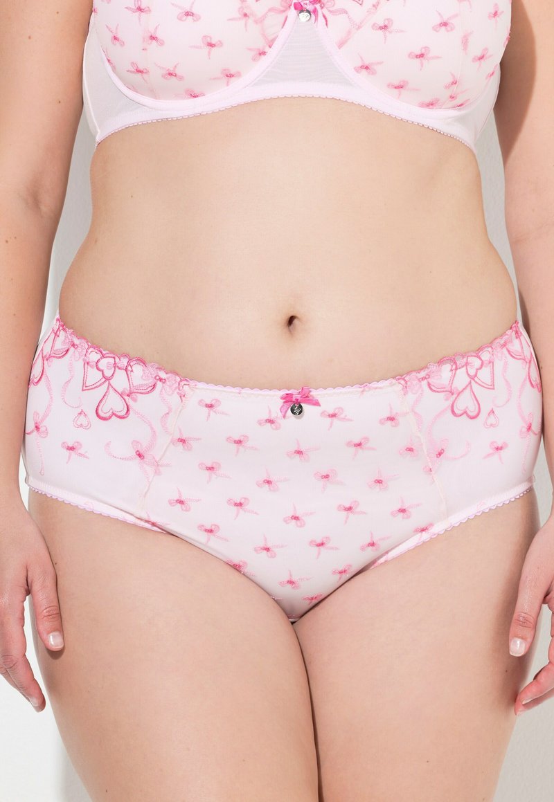 Růžové krajkové spodní prádlo s květinovým vzorem, vlnkovým okrajem a malou ozdobnou mašlí na pasu. Měkká, poloprůhledná tkanina.