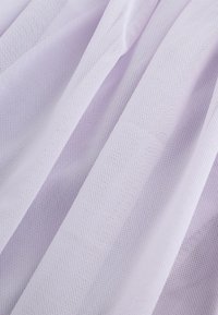 Helles Lavendel-Mesh-Gewebe mit strukturiertem Rastermuster, das in weichen Falten fällt. Das Material wirkt leicht und leicht durchsichtig.