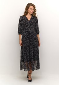 Black and grey leopard print maxi dress with long puff sleeves, a wrap neckline, cinched waist, and pleated skirt.