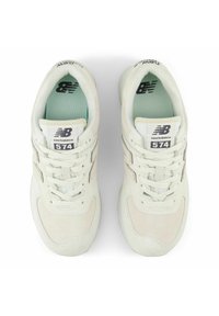 Ανοιχτό μπεζ αθλητικά παπούτσια με άνω μέρος από σουέτ, υφασμάτινες λεπτομέρειες και αφρώδες εσωτερικό σε ψηλό πράσινο χρώμ α. Διαθέτει επενδεδυμένη γλώσσα και κορδόνια.