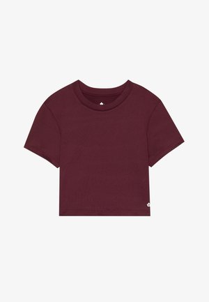 Vyno raudona trumpa marškinė su trumpomis rankovėmis, apvalia iškirpte ir lygiu, minkštu tekstūru. Papuoštos mažiu logotipu apatiniame šone.