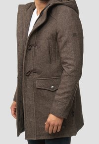 Brun uldblanding frakke med hætte, der har toggle-lukninger, sidelommer og struktureret stof. Slim-fit design med en blød overflade.